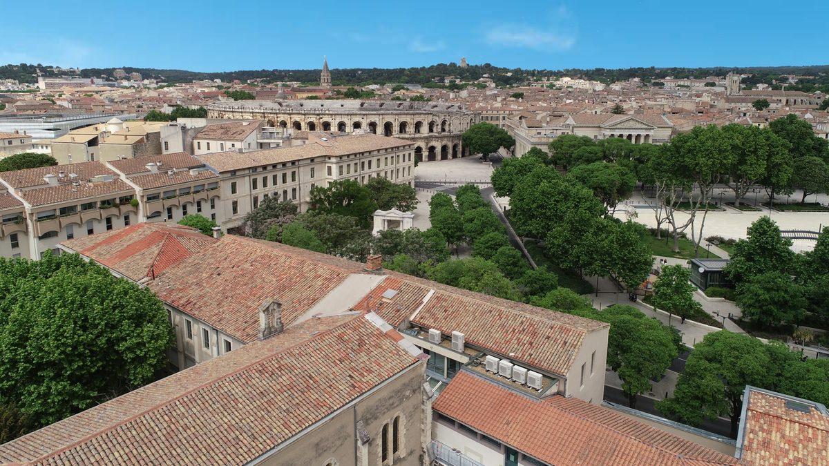 Vue aerienne du campus Pole Sup Saint Vincent de Paul a Nimes, avec les arenes en arriere-plan